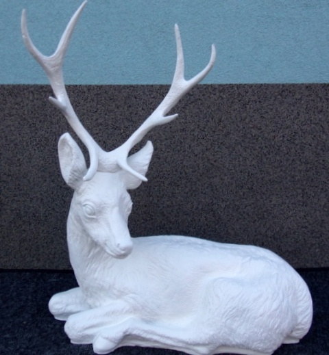 Jeleń leżący biały