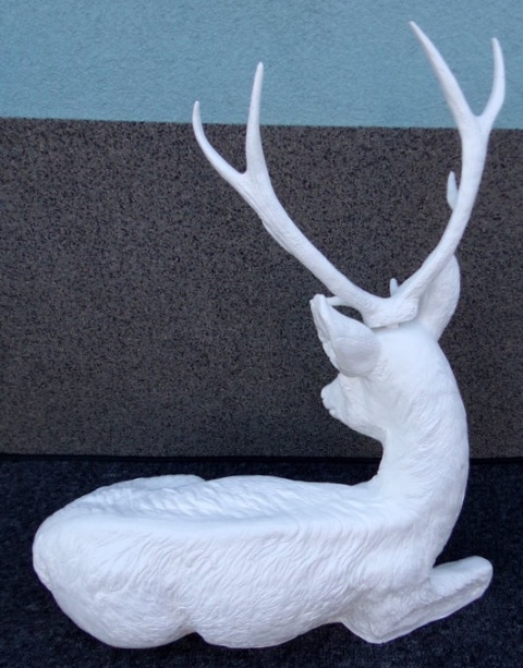 Jeleń leżący biały