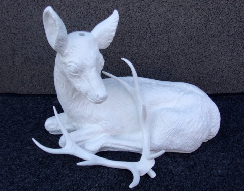 Jeleń leżący biały